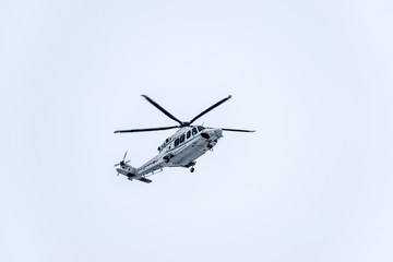 Fototapeta na wymiar A lage white helicopter flying overhead