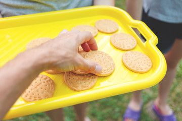Cookie lover. Man's hand is taking a cookie from a yellow tray