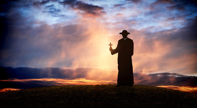 Pastor - Priest On The Hill At Sunset With The Cross