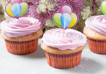 Delicious birthday cupcakes with pink cream.