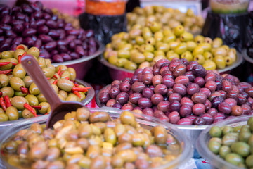 Containers with a variety of kinds olives in the market stall. Carmel Market, Tel Aviv, Israel