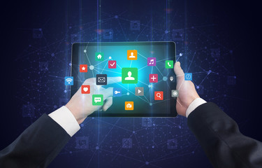 Hand using tablet with colorful bounce application symbols and icons concept