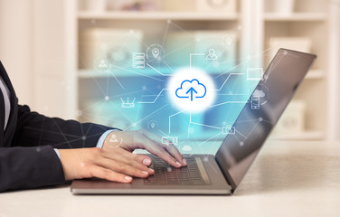 Business woman in homey environment using laptop with online storage and cloud technology concept