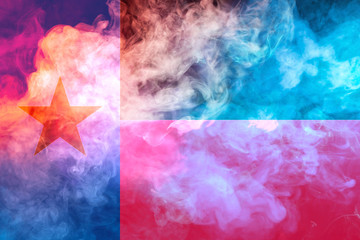 Fototapeta premium The national flag of the US state Texas in against a gray smoke on the day of independence in different colors of blue red and yellow. Political and religious disputes, customs and delivery.