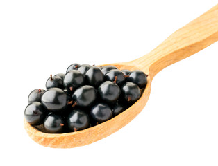 Black currant in wooden spoon isolated on a white.