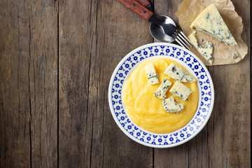 Italian food polenta with cheese on wooden table. Top view.