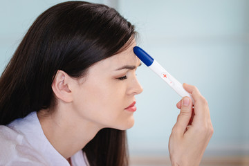 Obraz premium Young woman shocked to see a positive pregnancy test