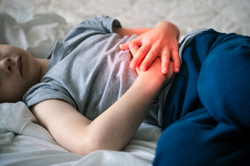 abdominal pain in a preschool child. poisoning in children. the boy holds his hands to the abdominal cavity