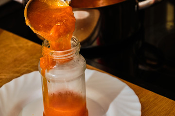 Pouring apricot marmelade in glass