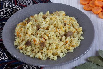 Rice with small pieces of meat and carrot on the grey plate