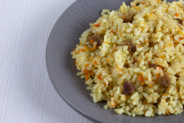 Rice with small pieces of meat and carrot on the grey plate