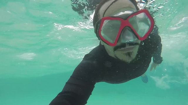 hombre debajo del agua con careta de snorkel