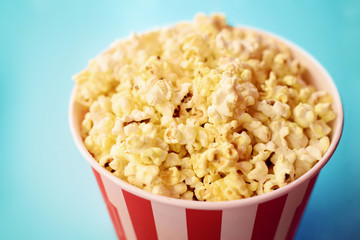 Popcorn in big paper bucket. Cinema concept. Eating popcorn while watching films