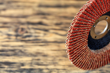 Sanding disc for wood and metal on the background of an old wooden board in blur.