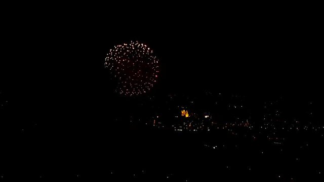 Astonishing fireworks over the city lights, slow motion aerial shot