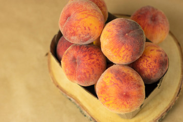 Ripe peaches in a plate on a wooden background. Close-up peaches Healthy food concept, plant background, natural eco-products, organic food, vegetarian, vegetables, raw, festival food