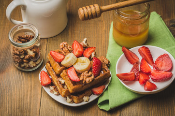Wafers. Homemade wafers decorated with banana, strawberry and walnut watered with honey. Top view