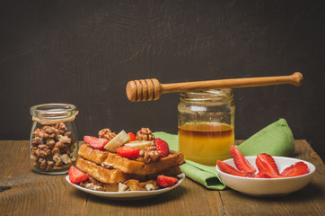 Wafers. Homemade wafers decorated with banana, strawberry and walnut watered with honey. Selective focus
