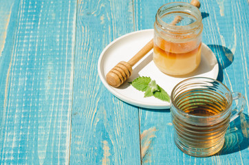 tea with mint and honey on a wooden blue table background. Copy space. Selective focus