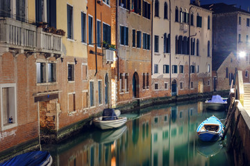Night view of a illuminated chanal and houses