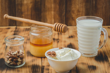 Healthy breakfast background. Honey, milk, cottage cheese and walnut on a wooden background.
