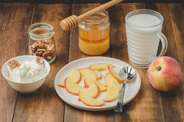 Healthy breakfast background. Peach, honey, milk, cottage cheese and walnut on a wooden background.