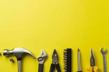 Metal tools on a yellow background, top view, a place to sign