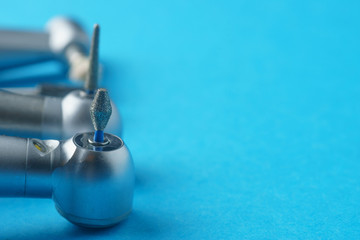 Dental burs on a blue background, close-up