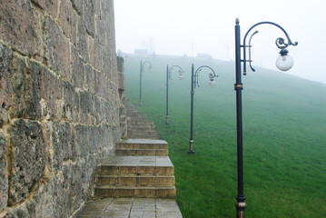 Ancient monastery in the fog, lampposts, landscape