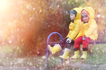 A child in a raincoat for a walk outside in autumn