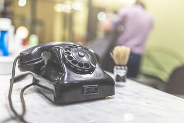 Close up of vintage phone and brush for shaving beard at men hair and beard salon.