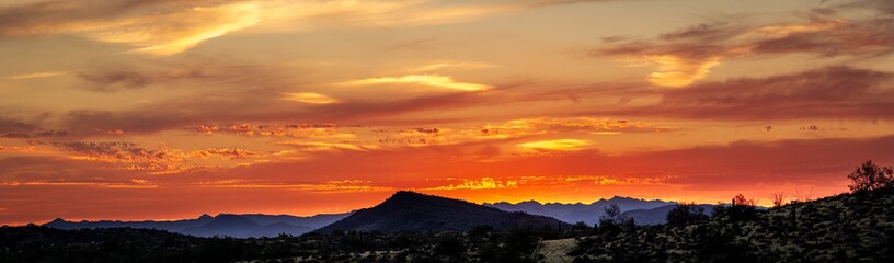 A sunset over a distant mountain in the Sonoran Desert of Arizona panorama