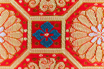 Close up part of gold-red-teal traditional silk fabric