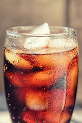 A glass covered with dew drops with a cold drink.