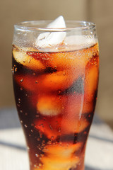 A glass covered with dew drops with a cold drink.