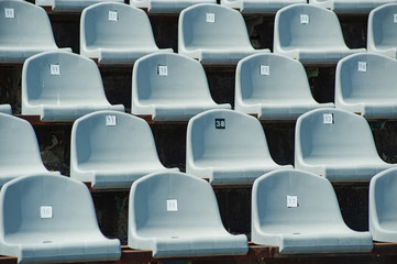 Fototapeta premium Sports concept. Rows of empty grey blue plastic seats at the tribune in an open sports stadium