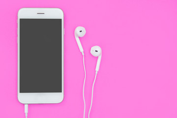 Smartphone with Earphones on pink background with copy space and clipping path. Flat lay. Top view.