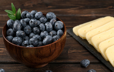 .cheese and blueberries on a wooden background