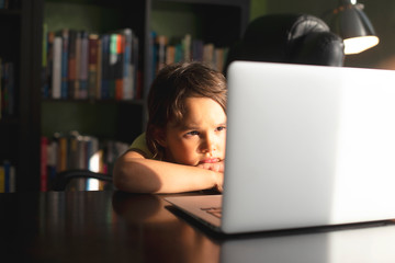Cute baby girl working on a computer at home.