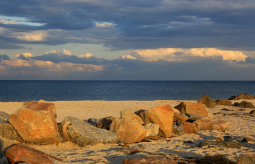  stones on sea sandy beach in evening light