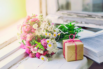 Bouquet of clover, a gift and a book on the window, selective focus.