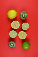 citrus and kiwi on a red background upside