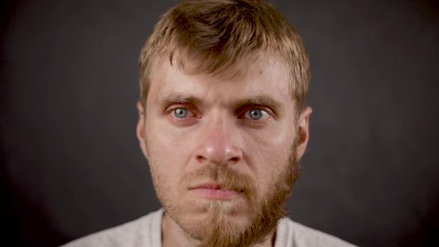 Handsome bearded hipster male express anger in the black studio
