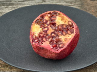 Delicious juicy red pomegranate.On wooden background