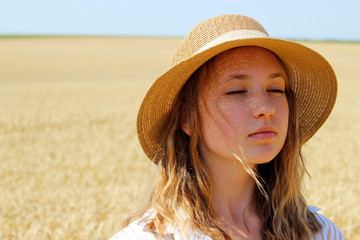 Cropped shot of a young girl spending time outdoors. Teenage girl wearing a hat, close up. Pretty woman closed eyes, outdoors.