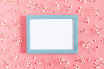Beautiful flowers composition. Empty photo frame, pink flowers on pastel pink background. Valentines Day, Easter, Birthday, Happy Women's Day, Mother's day. Flat lay, top view, copy space