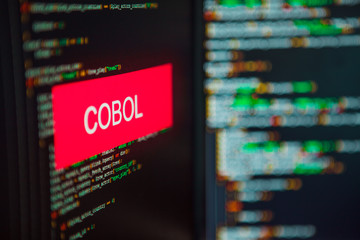 Programming language, COBOL inscription on the background of computer code.