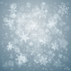 Christmas background of complex blurred and clear falling snowflakes in light blue colors with bokeh effect