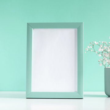 Blank frame for text, flowers on mint background. Flat lay, top view, copy space. square