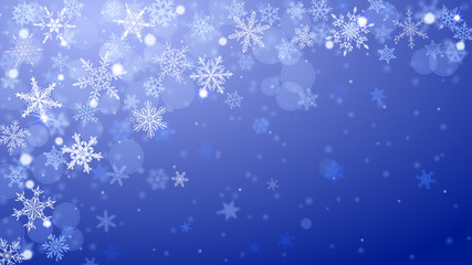 Christmas background of complex blurred and clear falling snowflakes in blue colors with bokeh effect